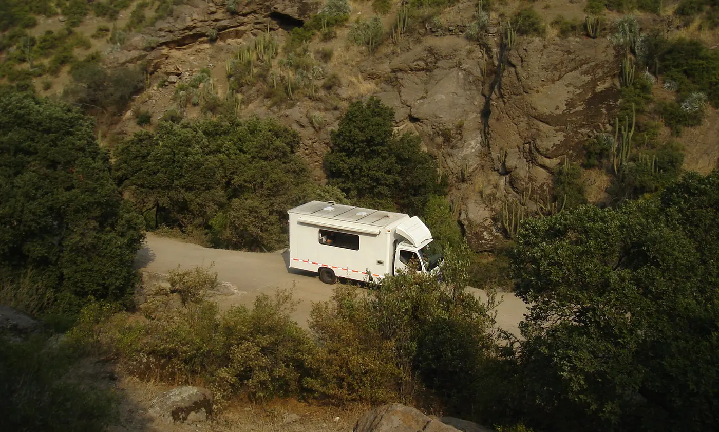 Unidad de cocina descendiendo un camino de tierra en una quebrada de cerro