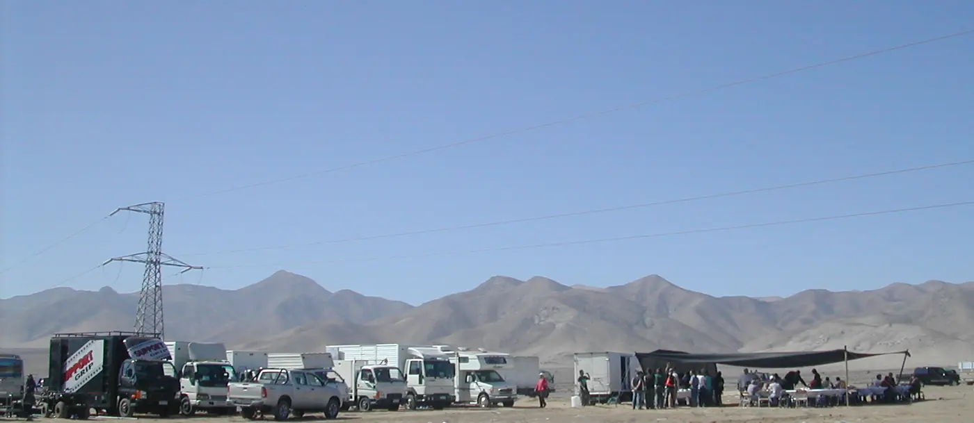 Fila de camiones y vehículos de producción desplegados en un terreno desértico